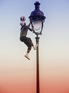 man wearing gray sweat shorts holding tower lamp