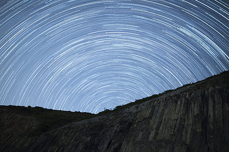 timelapse photography of green and grey mountain under sky with stars
