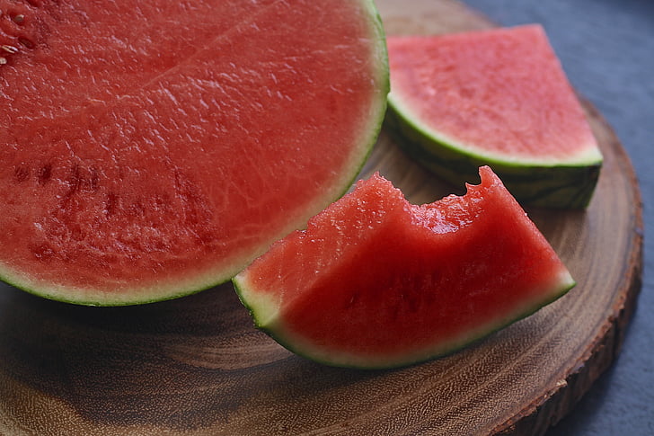 sliced watermelon on brown wooden surface