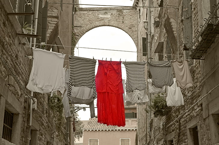 assorted-color clothes hanging between buildings