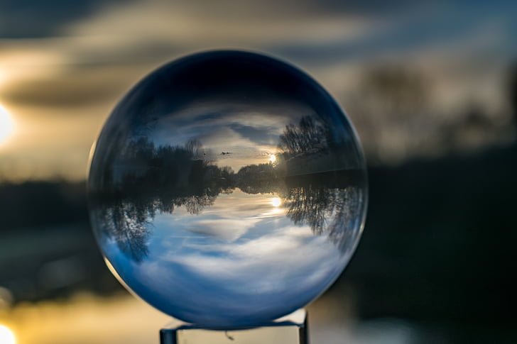 shallow focus photography of crystal ball reflecting lake