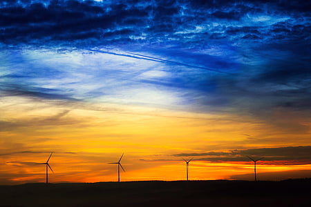 landscape photography of blue and yellow clouds in front of four windmills
