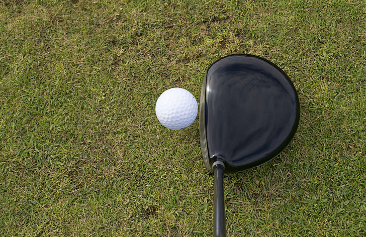 white golf ball beside black driver