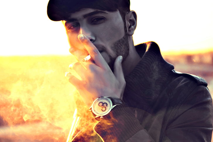 man wearing jacket while smoking cigarette