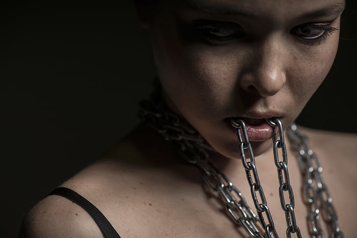 woman biting gray chain