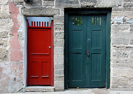 gray concrete building with green and red doors