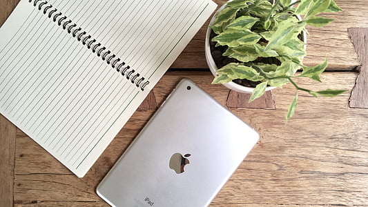 silver iPad near white notebook