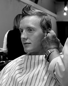 grayscale photography of barber cutting hair of a man