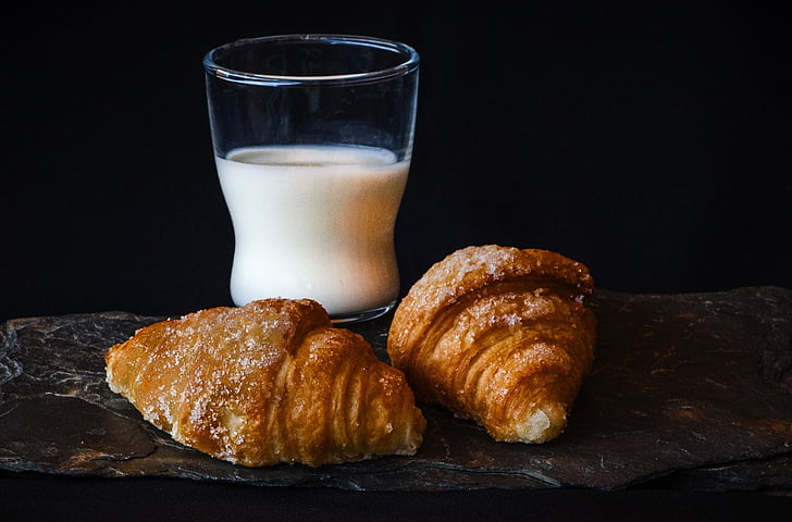 clear drinking glass with milk beside the bread