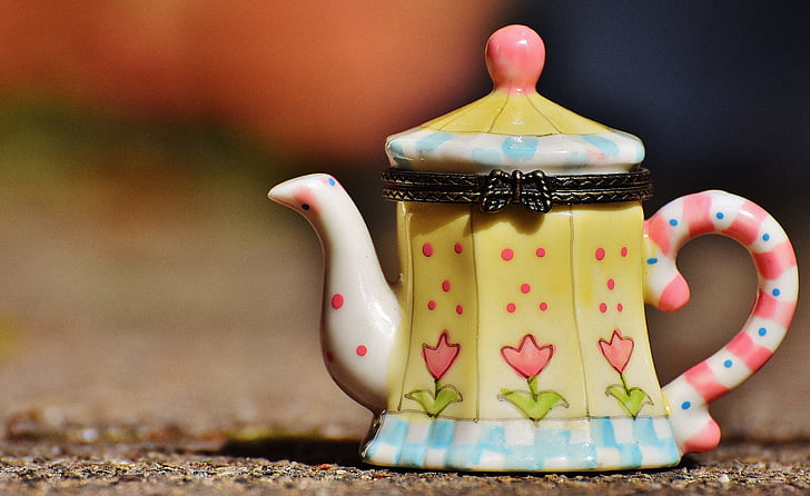 selective focus photography of yellow teapot