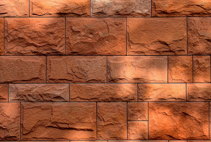 close up photography red brick wall during daytime