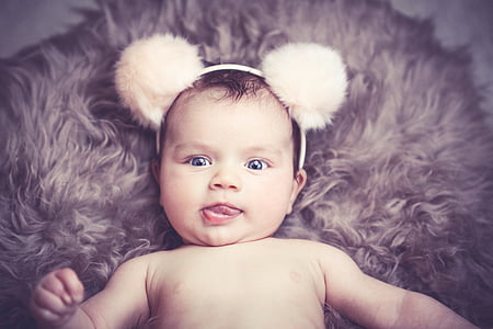 baby with white mickey mouse headband posing for photo