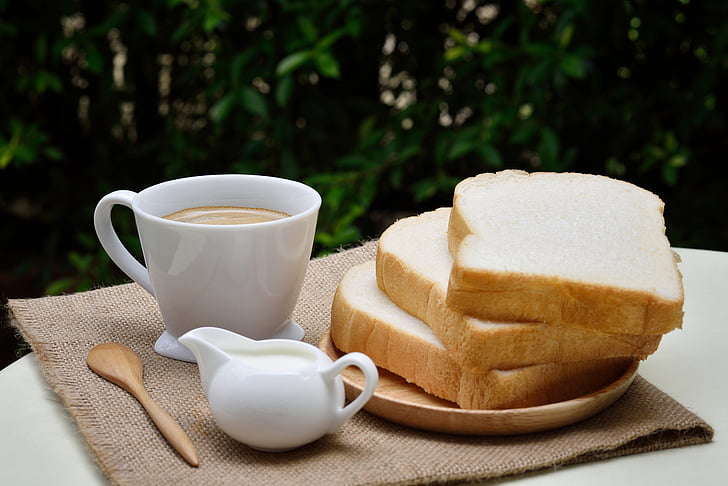 bread near coffee filled mug