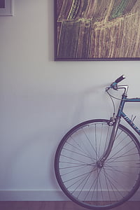 minimalist photography of road bike under black framed painting