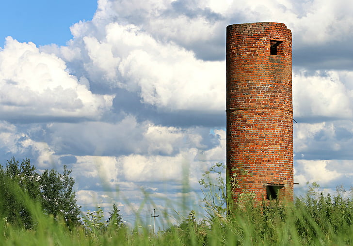 brown stoned tower surrounded by green grass field