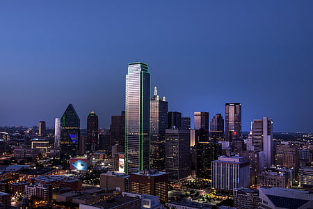 high-rise buildings under blue and gray sky at nighttime