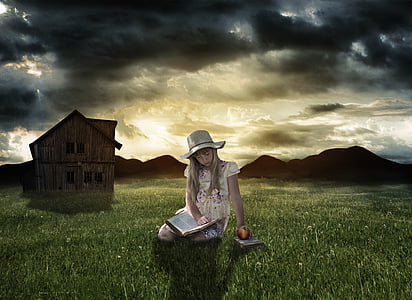 girl wearing white and purple cap-sleeved dress sitting on green grass while reading book under cloudy sky