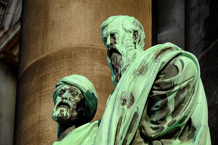 close-up photography of two man wearing green suit statue