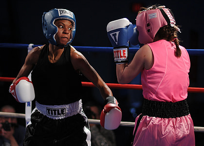 woman wearing black Title tops punching a woman wearing pink gear set