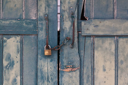 blue wooden door with brass-colored padlock
