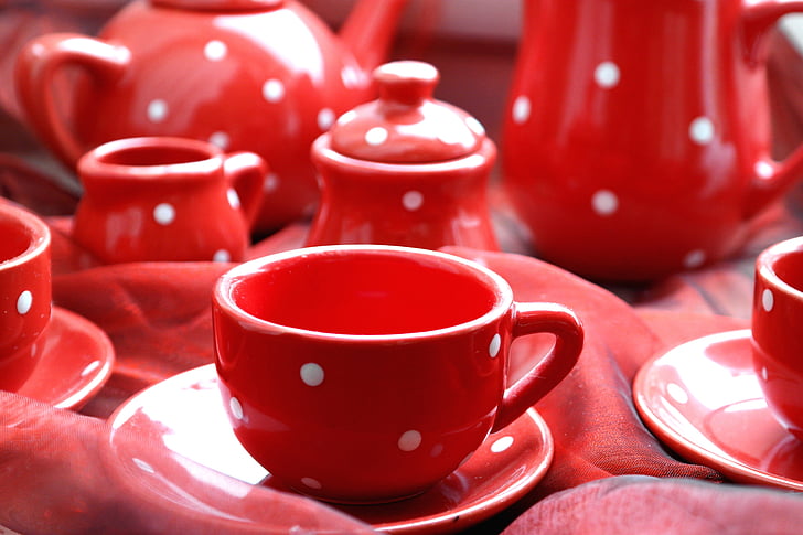 selective focus photography of red-and-white polka-dot ceramic teacup on saucer