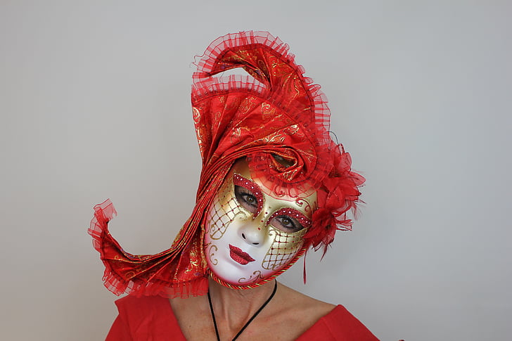 person wearing red and white masquerade mask