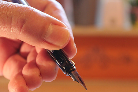 person holding calligraphy pen