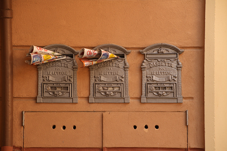 three antique gray mailboxes