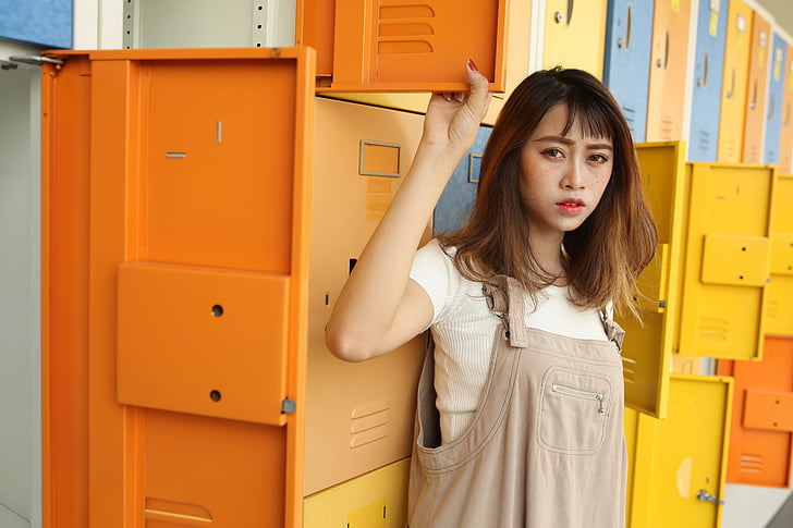 woman wearing gray overalls beside the locker