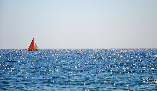 red and white sailing boat on body of water photography