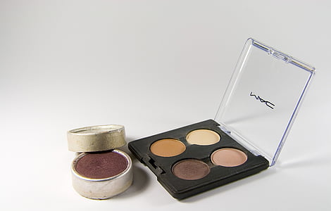MAC eyeshadow palette beside blush palette on white surface