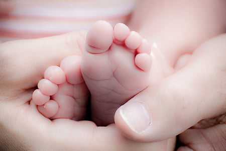 baby's foot being held by an adult