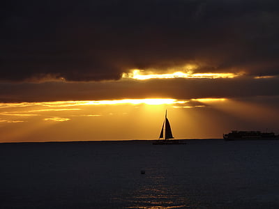 photography of silhouette sailboat on body of water during daytime