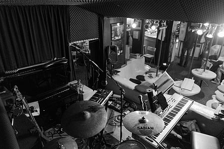 grayscale photo of drum set in music room