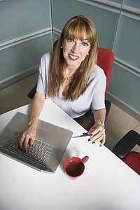 smiling woman in front of gray laptop computer