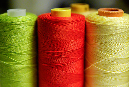 green, red, and yellow threads in shallow focus photography