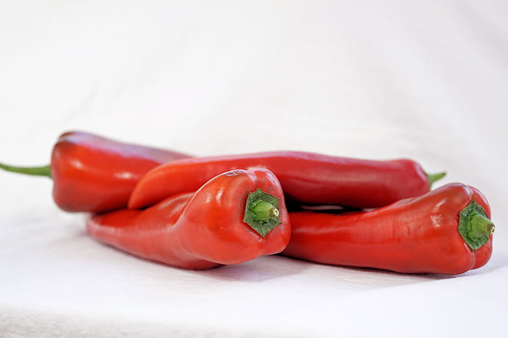 selective focus photography of four red jalapenos