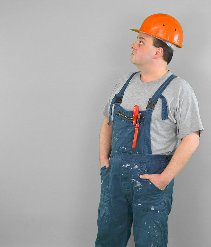 man wearing blue overalls and orange hard hat