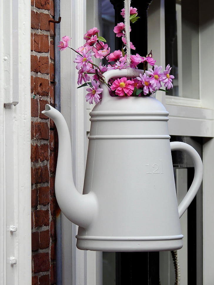 pink flowers on white watering can