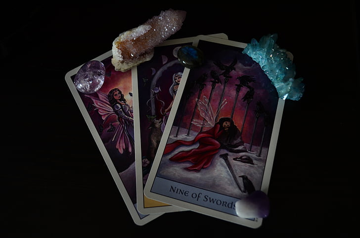 three tarot cards with gemstones