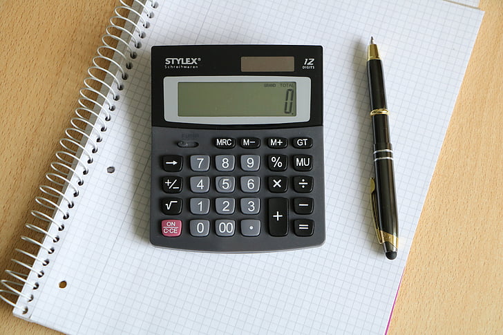 black Stylex calculator beside black twist pen