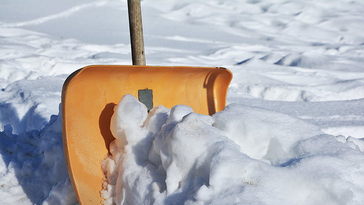 closeup photo of brown snow shovel near ice