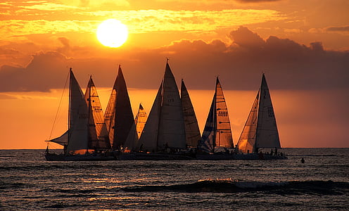 group sailing boat on body of water during sunset