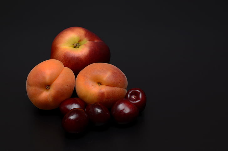 Apples and orange fruit with black background