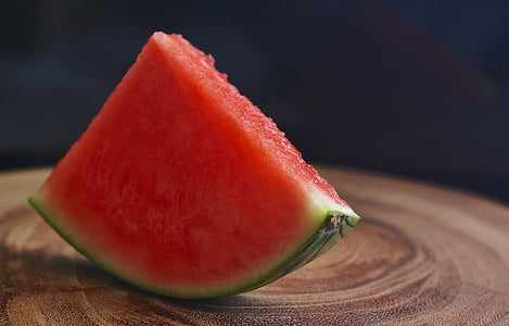 tilt shift lens photography of sliced watermelon on brown wooden table