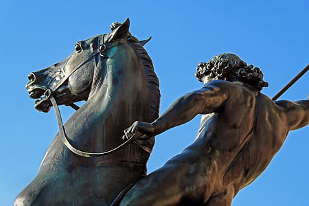 man holding spear on horse statue