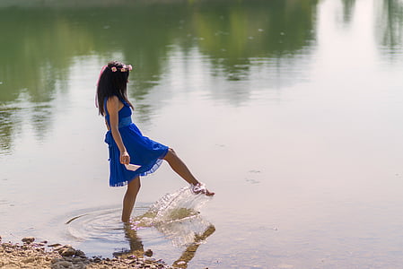 girl wearing blue sleeveless dress on body of water