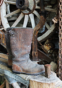 pair of brown leather boots near carriage wheel