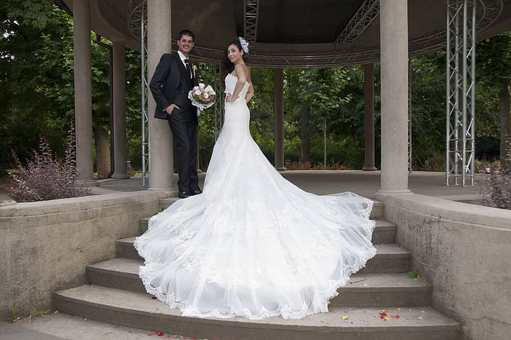man in black suit standing beside woman wearing white wedding dress