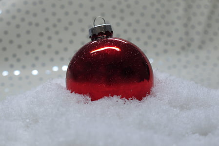 photo of red bauble on top of white surface